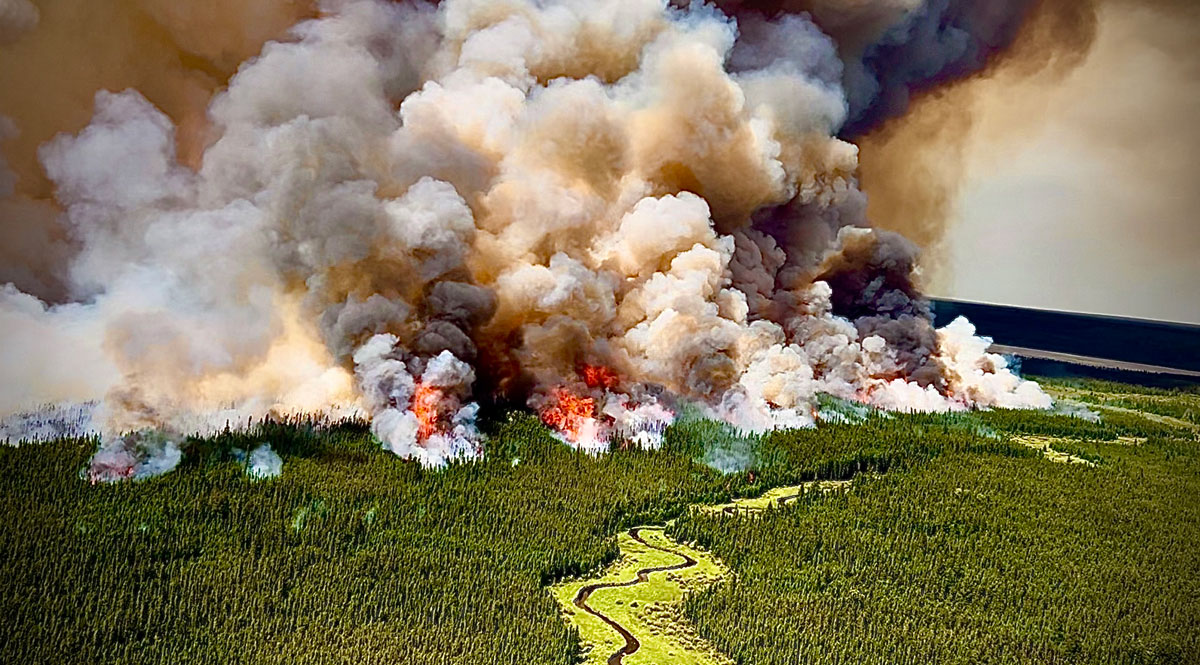 aerial handout photo from the Saskatchewan Public Safety Agency, taken in July/August 2025, shows billowing smoke and flames from the Muskeg, Trail, and Knee fires in northern Saskatchewan, Canada. 