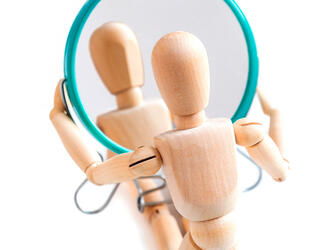 Wooden dummy looks at its reflection in the mirror © GIOIA Photo / Shutterstock.com
