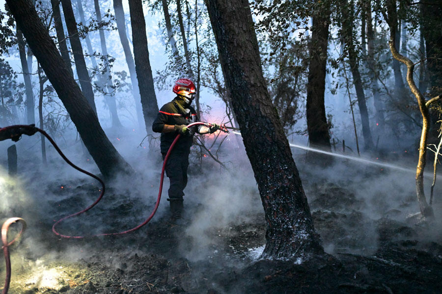 Firefighter work to extinguish a fire in the Broceliande forest, in Trehorenteuc, western France, on July 17, 2025. 