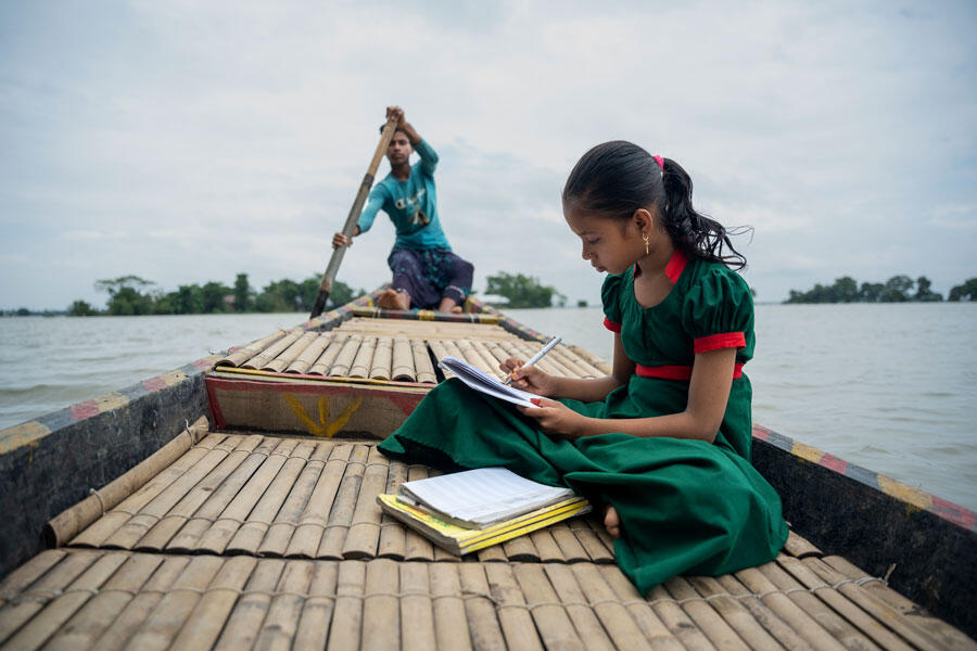 10-year-old girl from Manikpur does her homework on her uncle’s boat