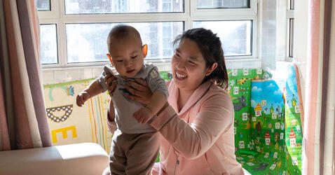 Su Yue and her son play in the living room of their house in Beijing, China 
