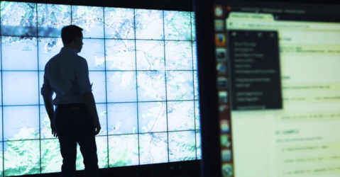 Man standing in front of wall of screens.