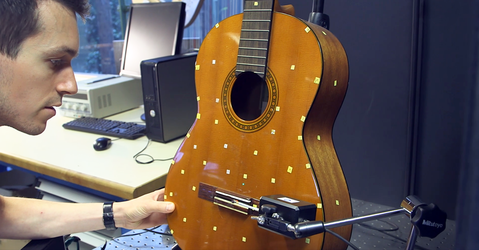 Physicist studying the acoustics of a guitar