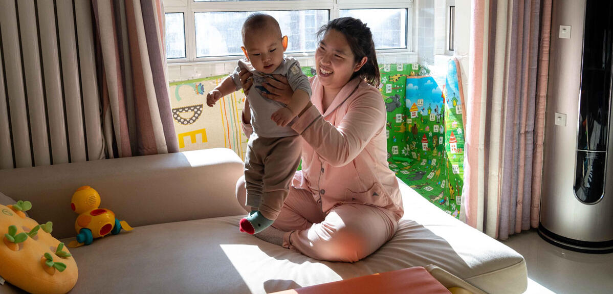 Su Yue and her son play in the living room of their house in Beijing, China 
