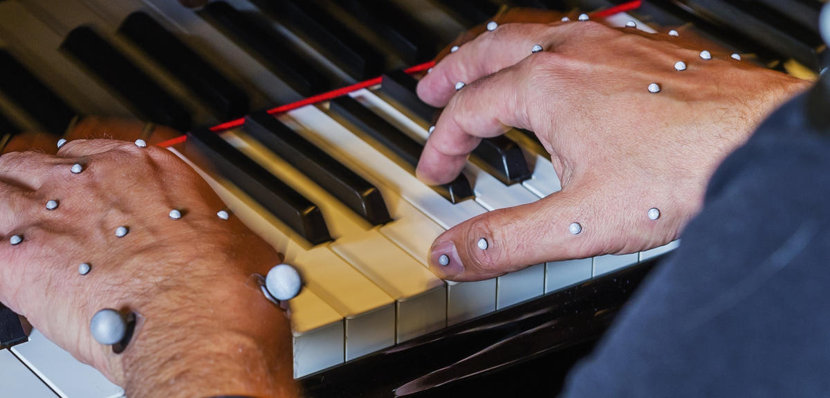 Hands of a piano player with motion capture markers.